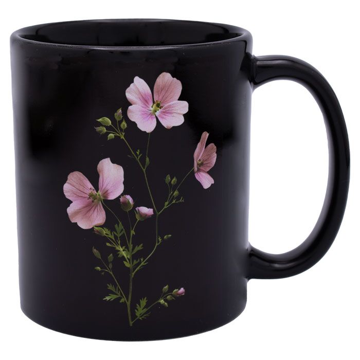 Schwarze Keramiktasse mit einer Blume als Druckmotiv